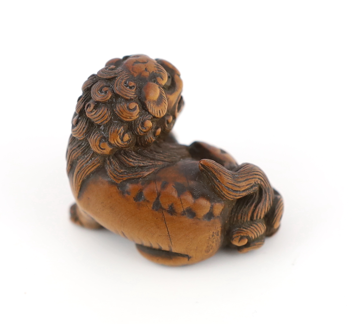 A Japanese carved wood netsuke of a recumbent Shi-Shi, signed Toyomasa?, late 18th century